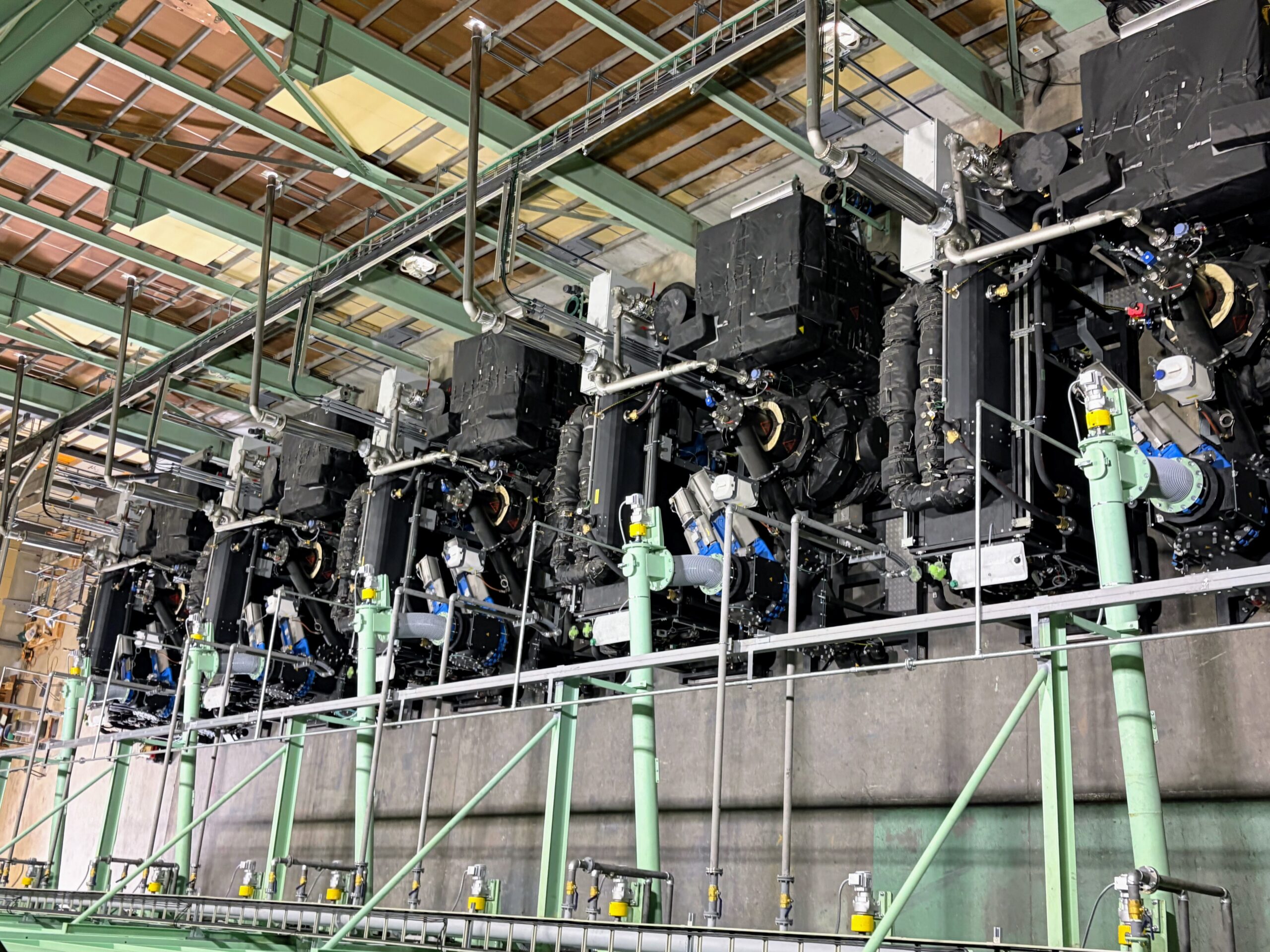 A row of biomass gasification CHP units installed in a plant hall